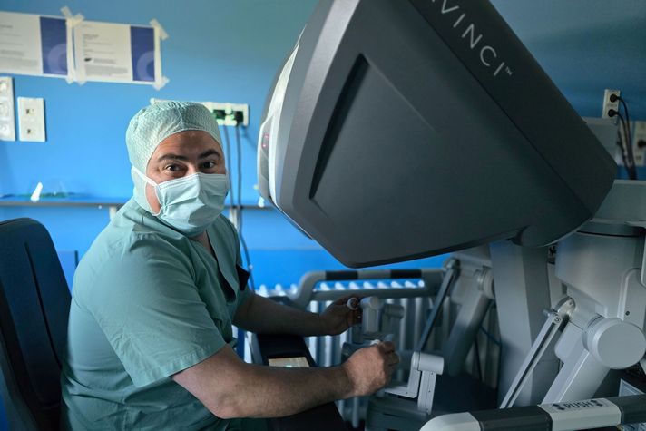 Alexander Gamrekeli, Sektionsleiter der Thoraxchirurgie, sitzt am DaVinci-Operationsroboter.