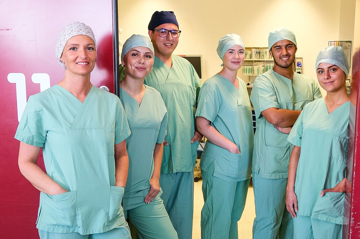 Gruppe Auszubildender (OTA und ATA) vor OP-Saal im Klinikum Saarbrücken in OP-Kasacks