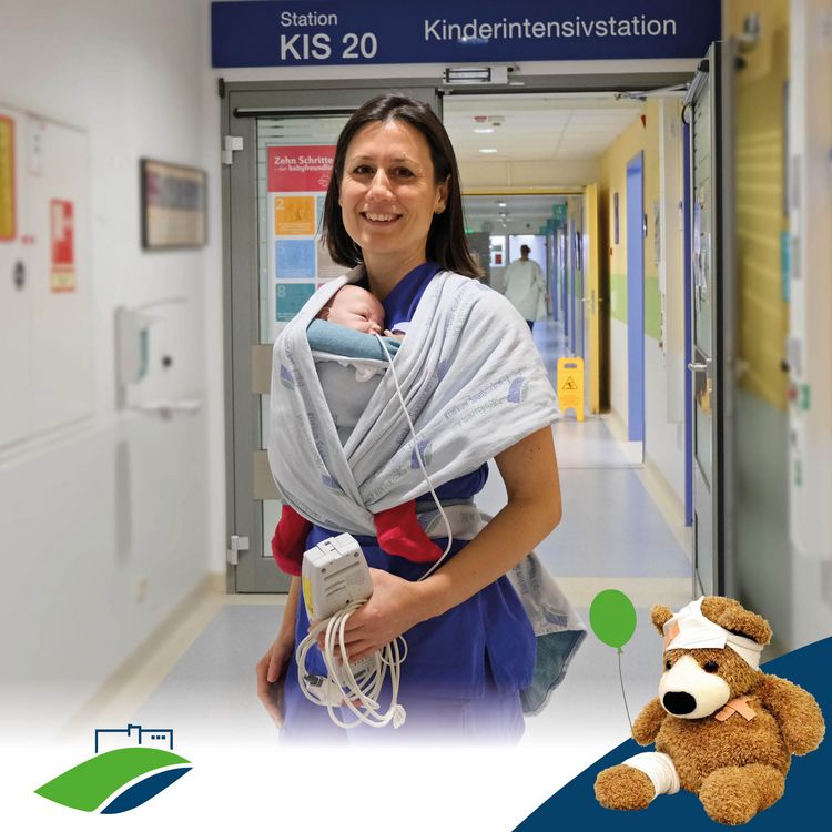 Serie #TeamKiKli: KIS – Pflege, die stark macht; stellvertretende Stationsleiterin Bianka Lambert mit Puppe im Tragebuch vor der Kinderintensivstation