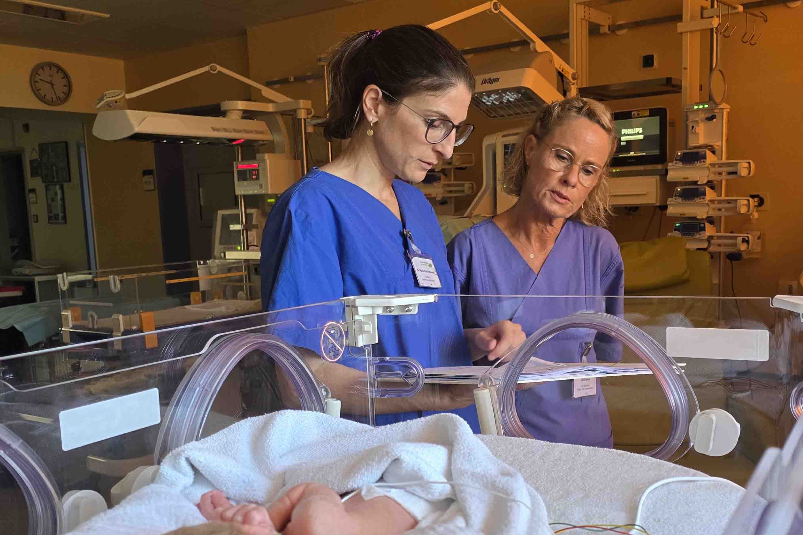 Chefärztin Dr. Marie-Claire Detemple und leitende Oberärztin Doris Anhalt blicken in eine Akte auf der Kinderintensivstation im Klinikum Saarbrücken.