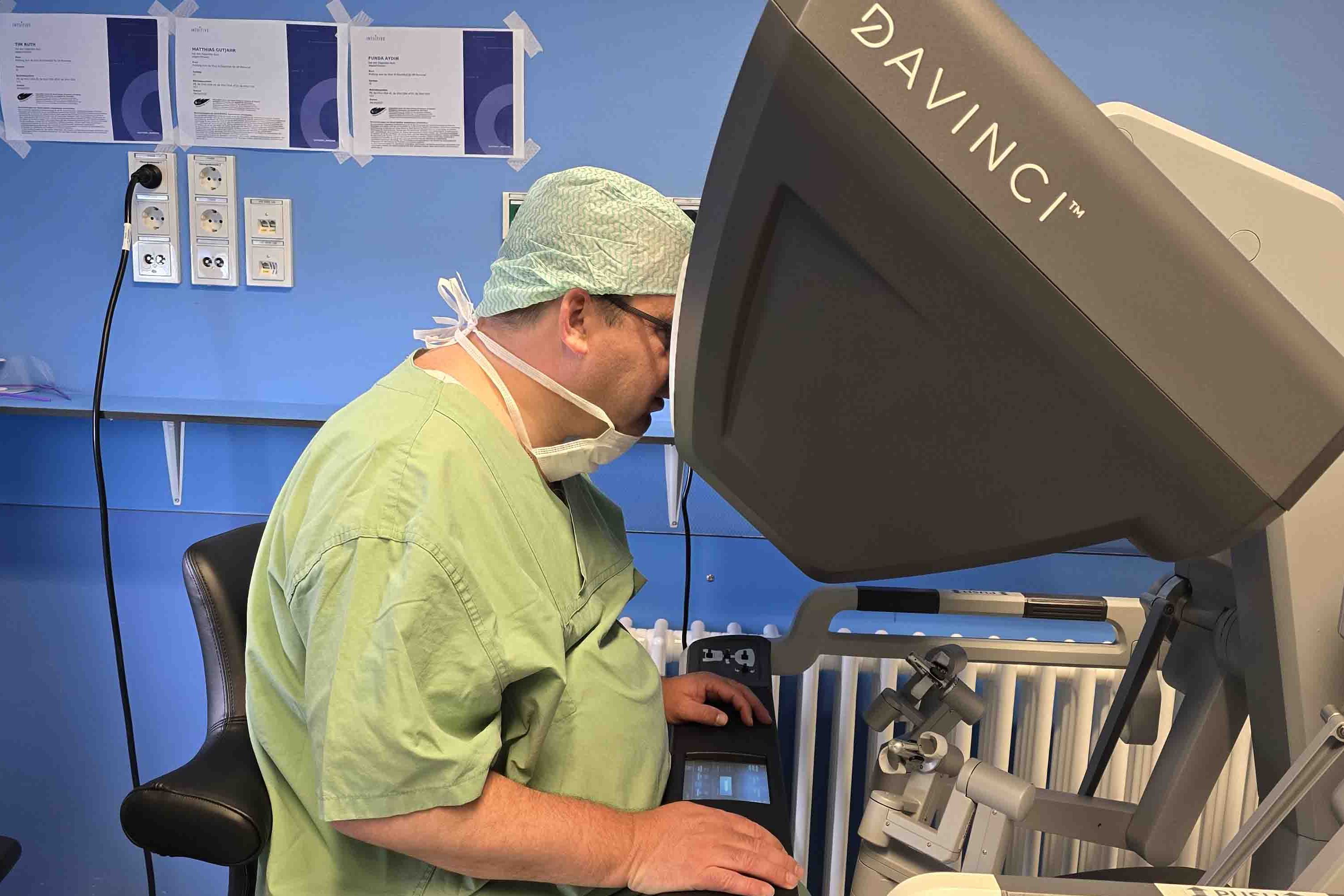 Dr. Magnus Jung, saarländischer Gesundheitsminister, blickt in die Konsole des Operationsroboters.
