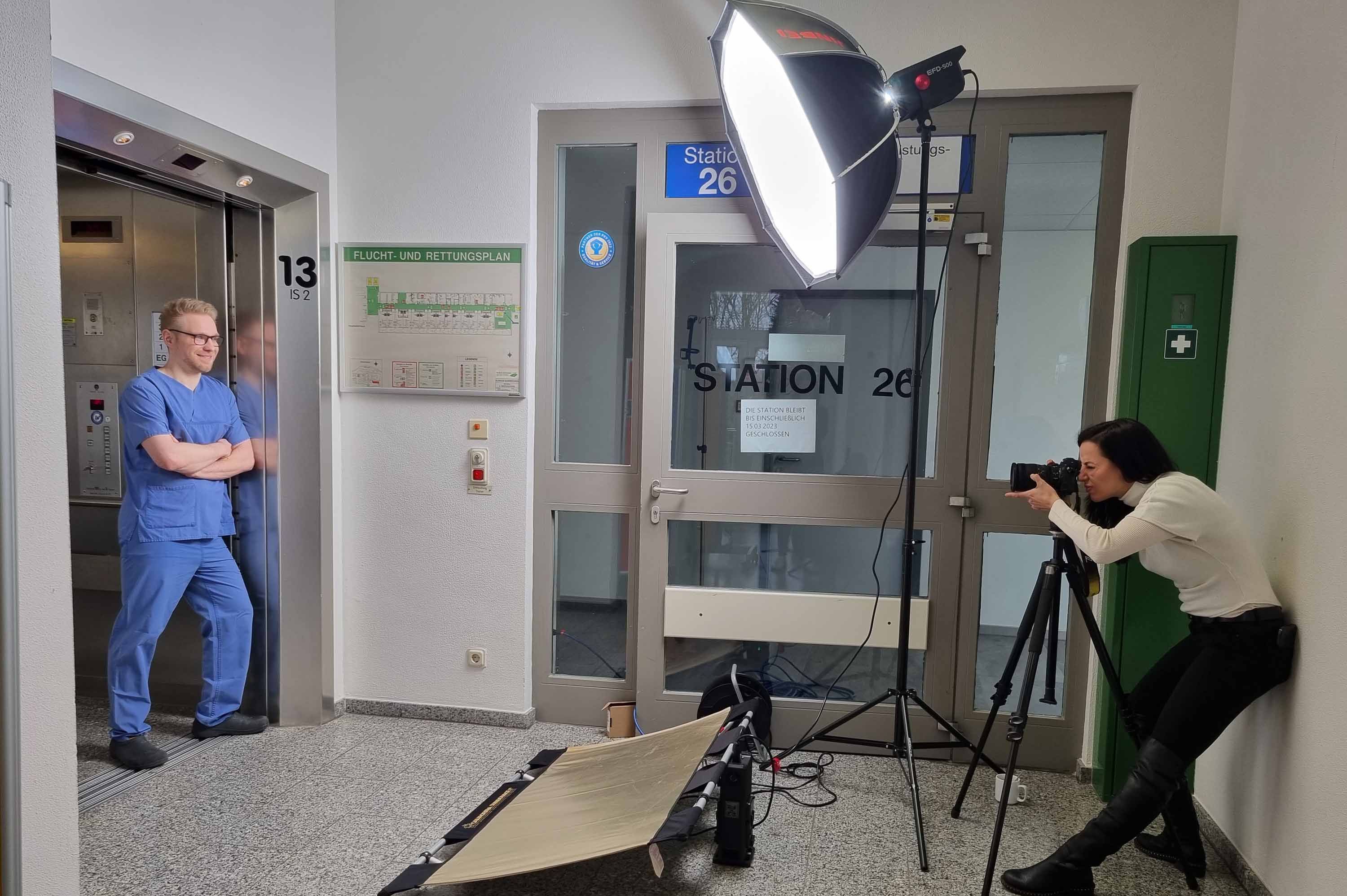 Die Fotografin schießt ein Foto von Pfleger Sascha, der im Aufzug steht.
