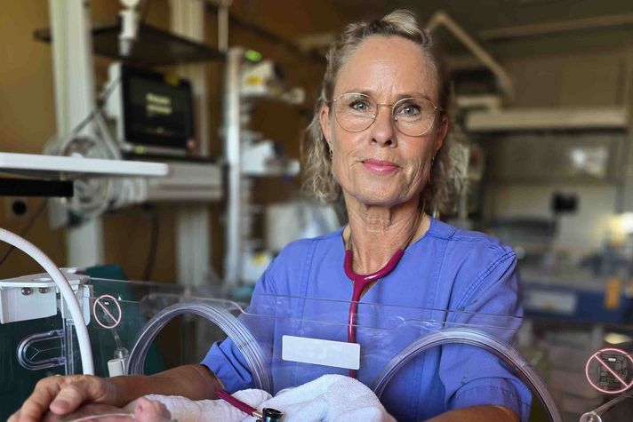 Doris Anhalt steht vor einem Baby-Inkubator und blickt in die Kamera.