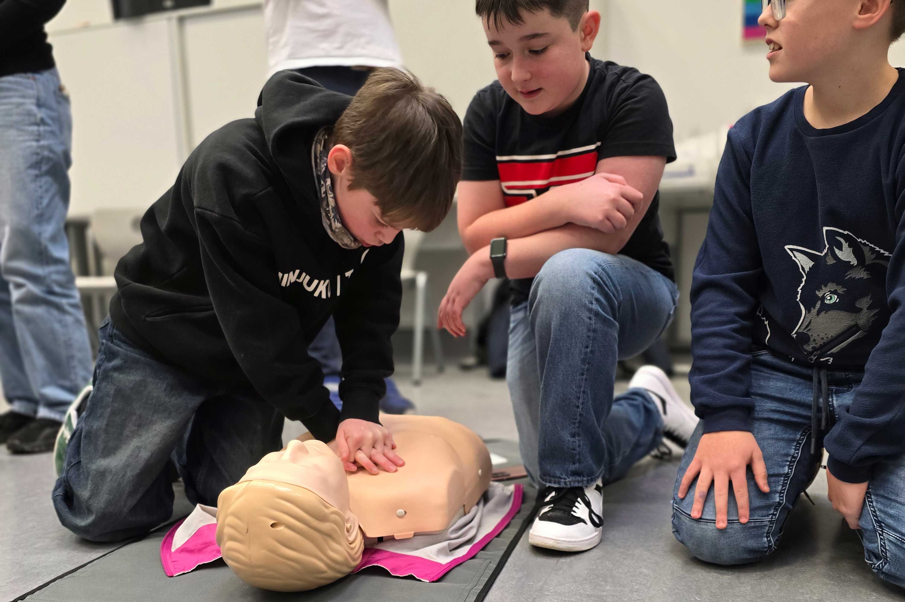 Die Schüler des Klasse 6 üben an Puppen, wie Wiederbelebung bei einem Herzkreislaufstillstand funktioniert.