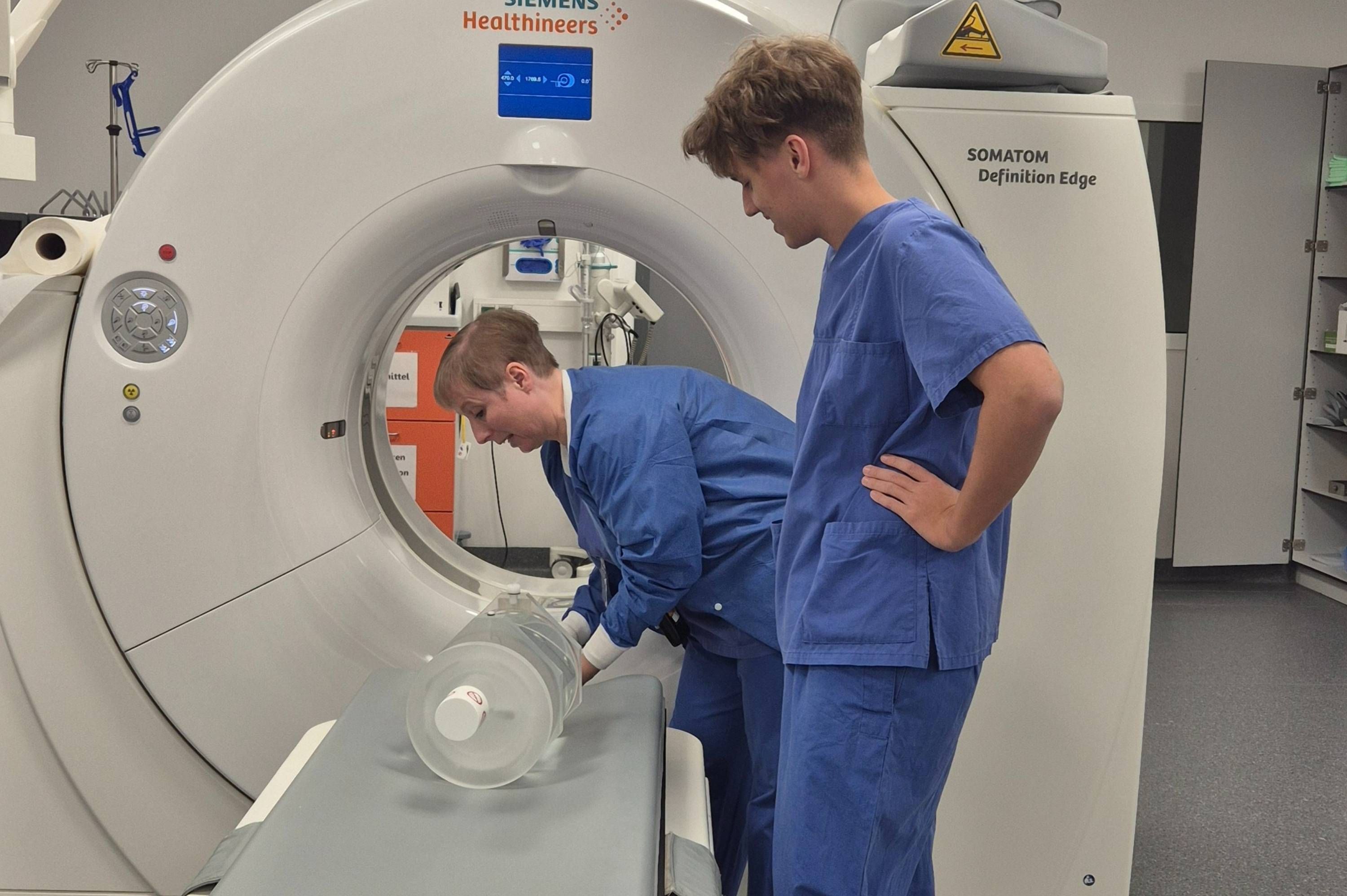 MT-R Esther Uhl erklärt einem Praktikanten Meßverfahren am CT im Schockraum des Klinikum Saarbrücken