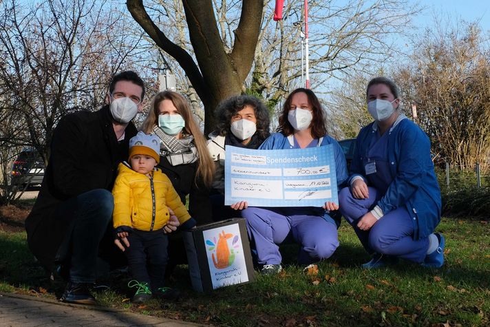 Gruppenfoto während der Spendenübergabe auf dem Gelände des Klinikums Saarbrücken: Sascha und Daniela Just mit Sohn Samuel Elias, Eva Vogelgesang (zweite Vorsitzende des Vereins ‚Känguruh-Kinder‘ e. V. sowie pflegerische Leitung der Kinderintensivstation KIS 20 Anja Vogt und Stellvertretung Milena Braun (v.l.n.r.).