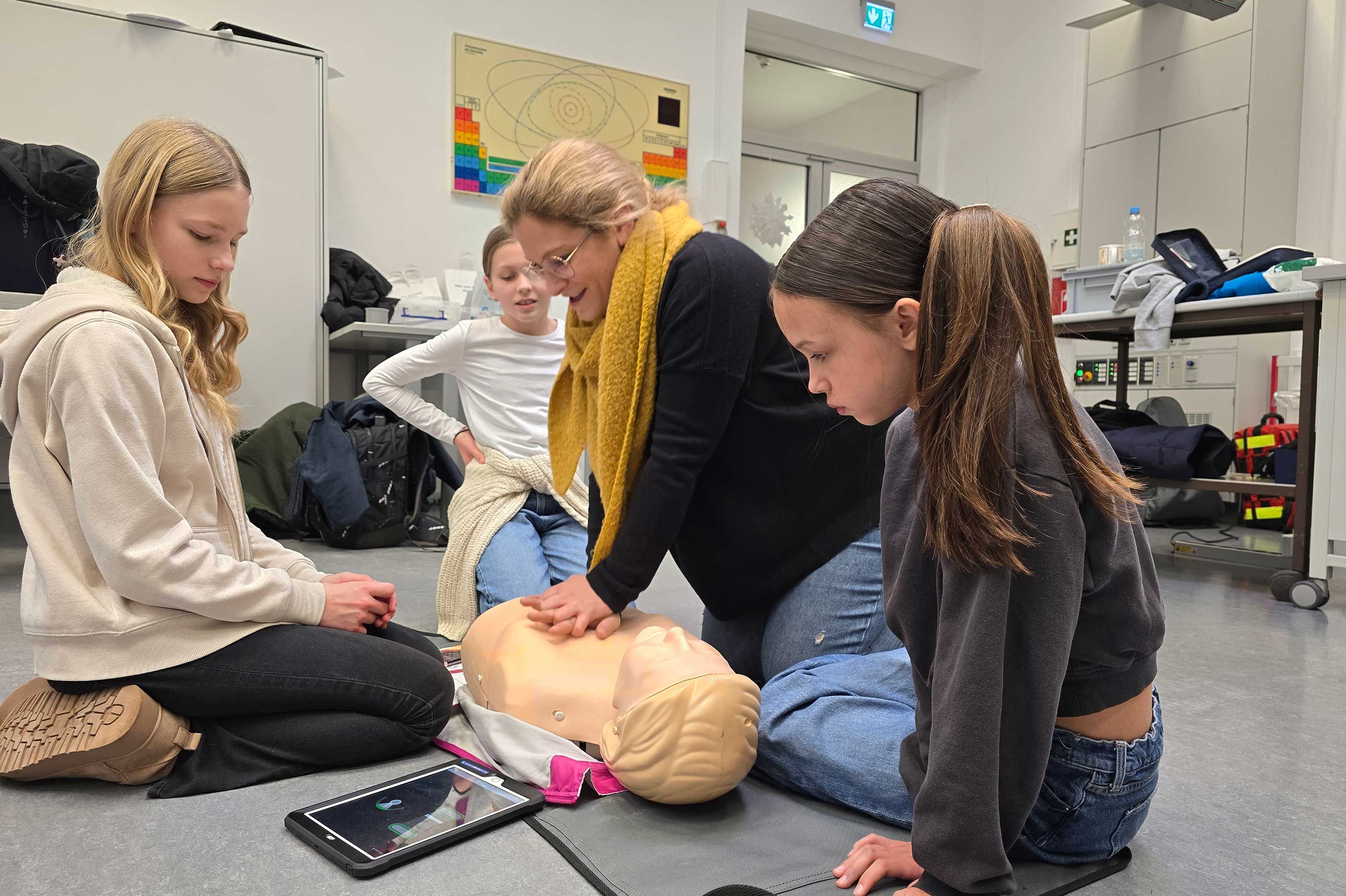 Schülerinnen und Schüler des Illtal-Gymnasiums Illingen üben gemeinsam mit Lehrerin Sabrina Grenner, was im Fall eines Herzkreislaufstillstands zu tun ist.