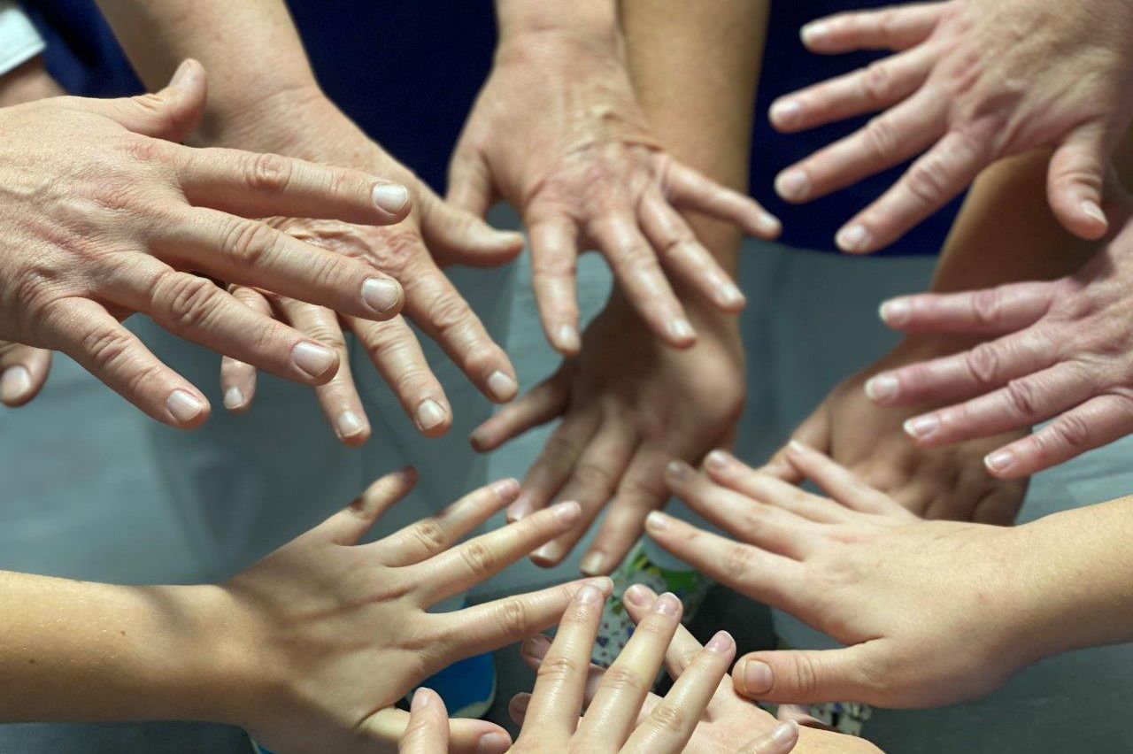 Hände verschiedener Nationalitäten treffen zusammen im Kreis