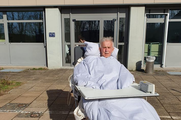 Patient Karl-Heinrich Hietkamp im Mobilisationsstuhl draußen vor dem Klinikum Saarbrücken