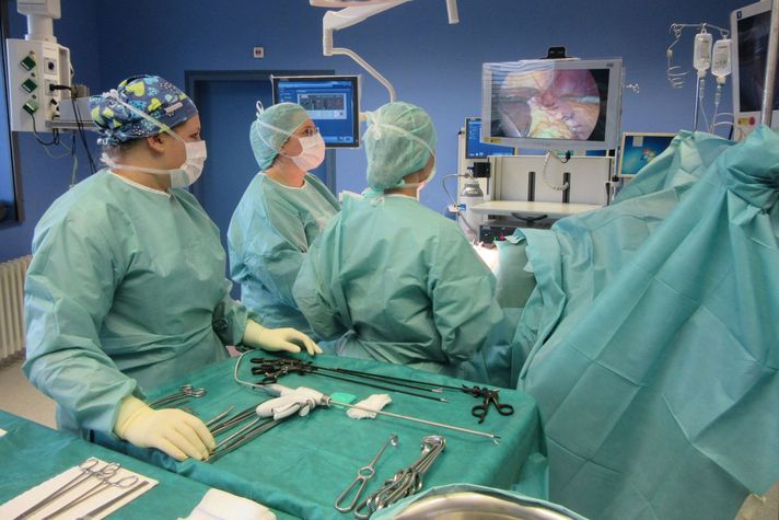 Das medizinische Team des Adipositaszentrums führt gemeinsam eine Operation durch. Die Fachkräfte tragen sterile OP-Kleidung und arbeiten konzentriert an einem Patienten auf dem OP-Tisch. Im Vordergrund ist ein Instrumententisch zu sehen.