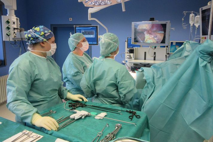Das medizinische Team des Adipositaszentrums führt gemeinsam eine Operation durch. Die Fachkräfte tragen sterile OP-Kleidung und arbeiten konzentriert an einem Patienten auf dem OP-Tisch. Im Vordergrund ist ein Instrumententisch zu sehen.