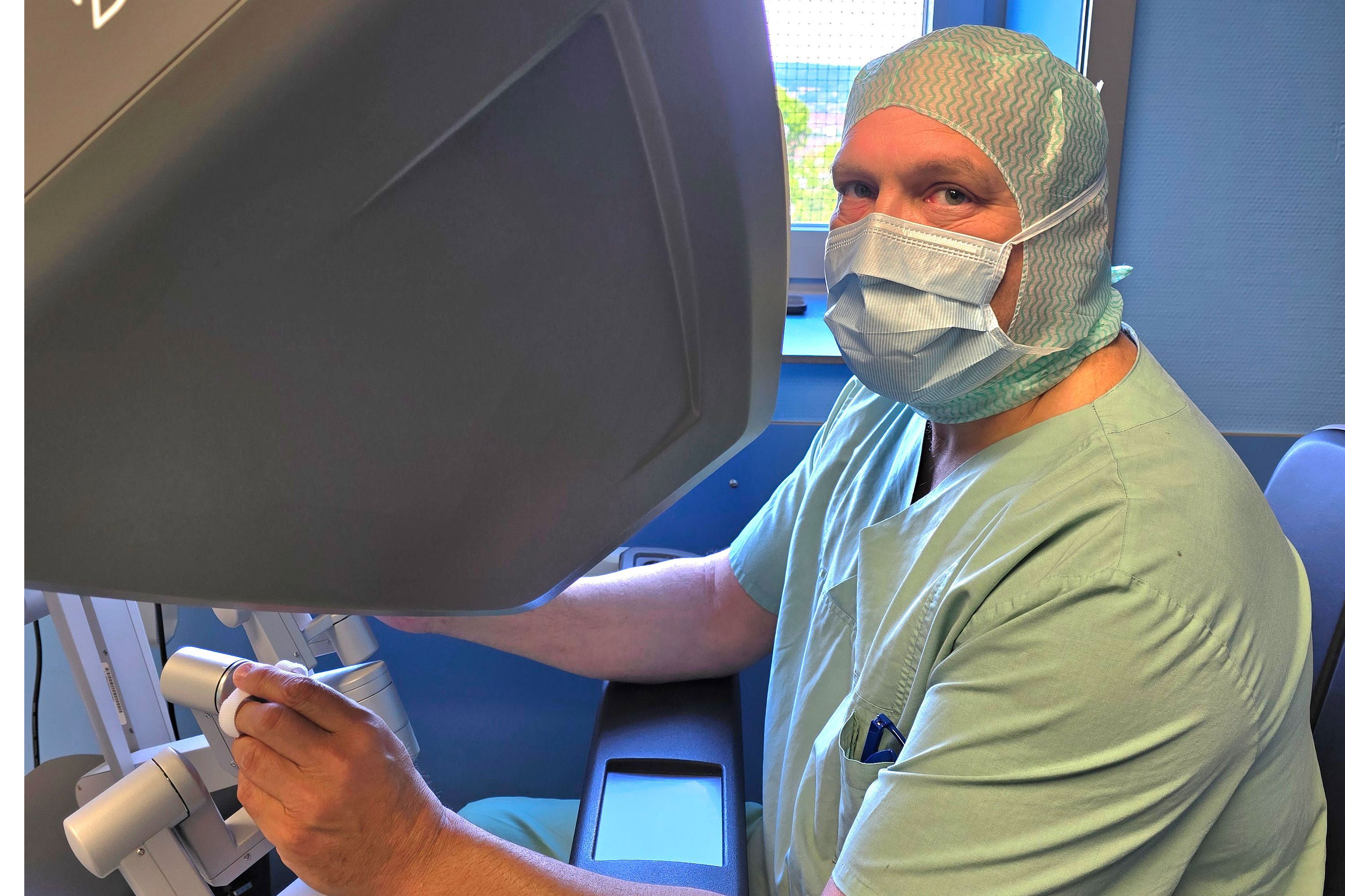 PD Dr. Sascha Baum, Chefarzt der Frauenklinik, sitzt am DaVinci-Operationsroboter.