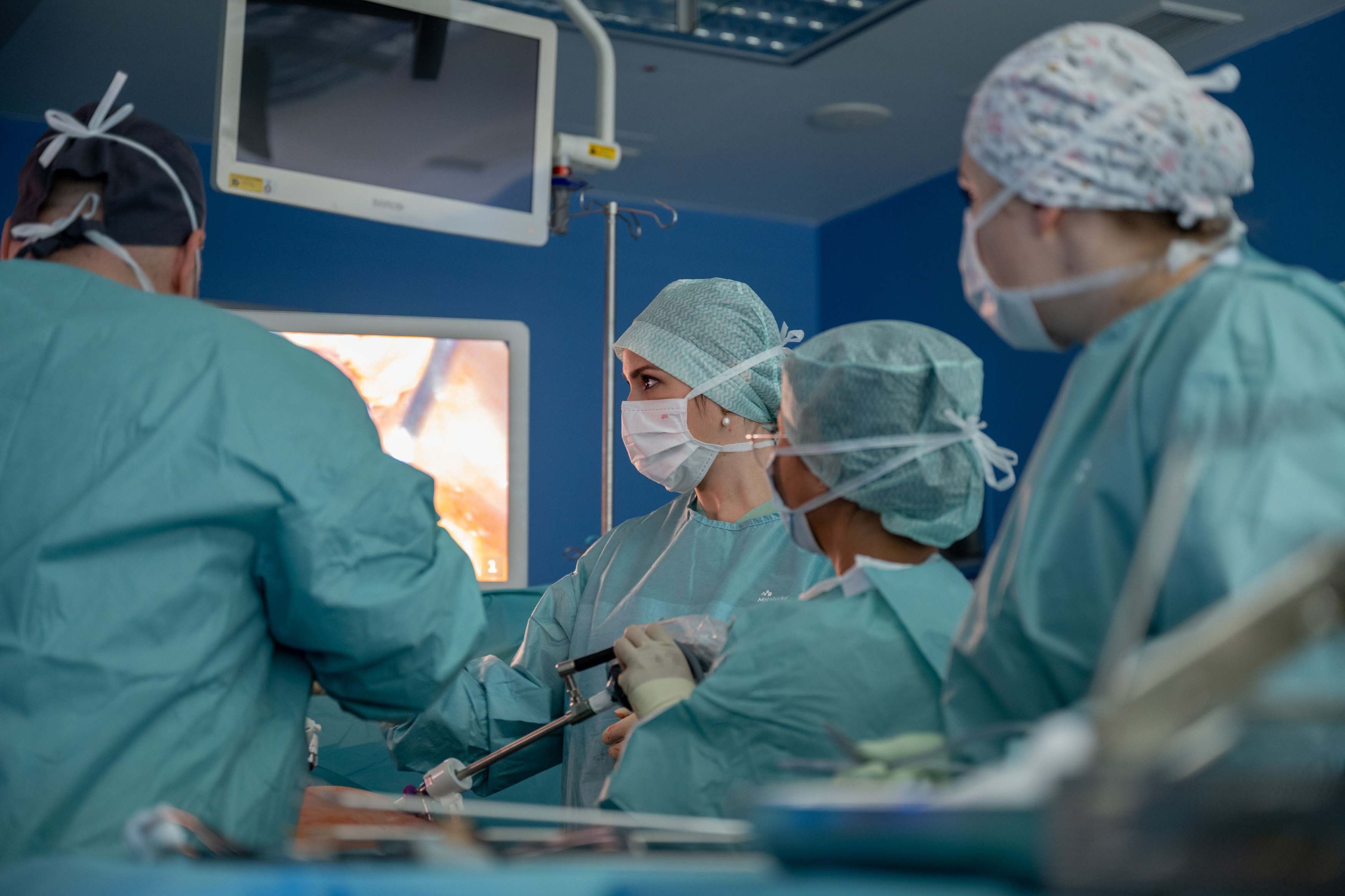 Fachpersonal führt eine Operation im OP-Raum im Klinikum Saarbrücken durch. Die Fachkräfte tragen sterile OP-Kleidung. Die Szene zeigt konzentrierte Zusammenarbeit an einem Patienten auf dem OP-Tisch, umgeben von chirurgischen Instrumenten und medizinischen Geräten.