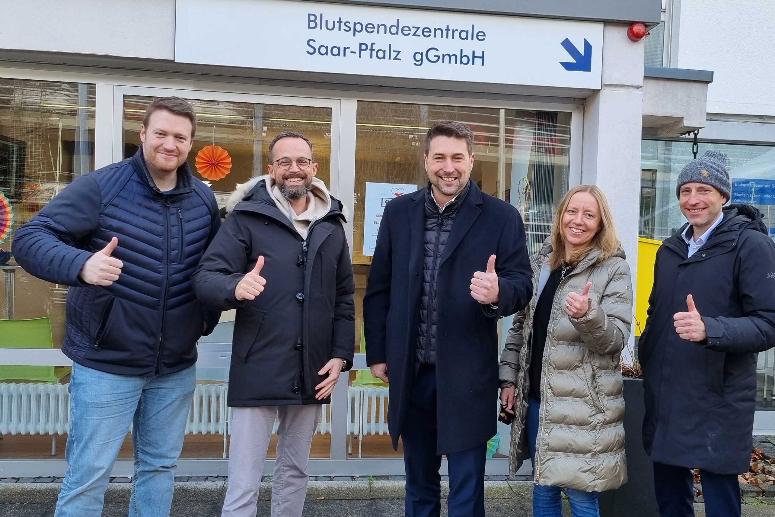 Vor der Blutspende stehen Aufsichtsratsvorsitzender Tobias Raab, Klinikum-Geschäftsführer Dr. Christian Braun, Oberbürgermeister Uwe Conradt, Koordinatorin für Betriebl. Gesundheitsmanagement der Landeshauptstadt Barbara Heydt sowie Blutspendezentrale-Geschäftsführer Matthias Mudra. 