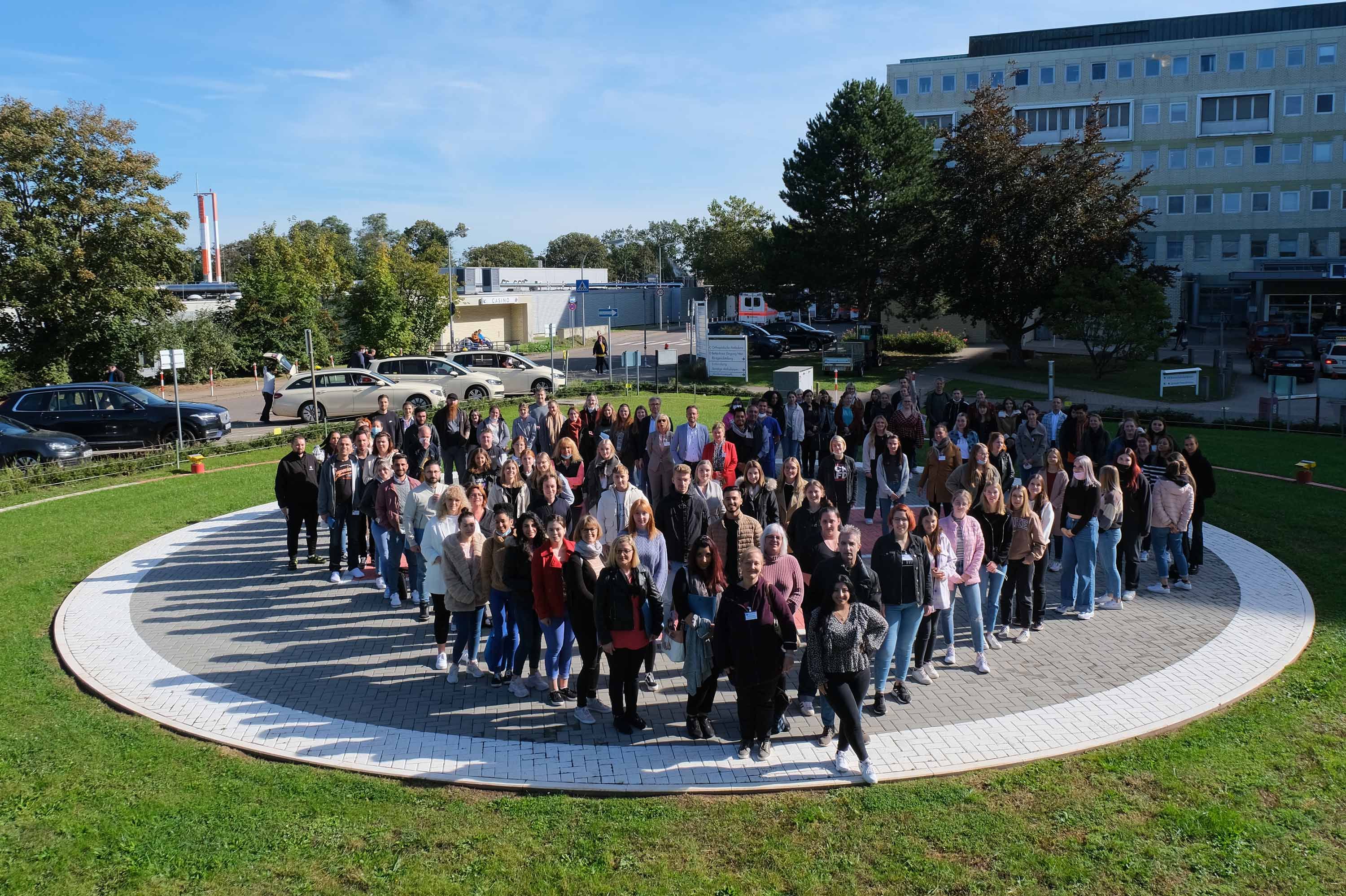 Gruppenaufnahme auf dem Hubschrauberlandeplatz des Klinikums Saarbrücken: 69 "Neue" Auszubildende